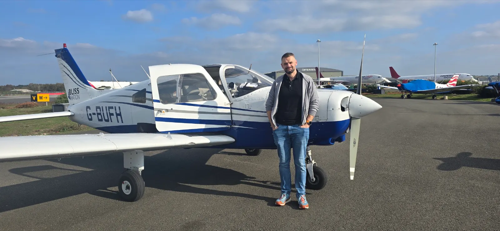 Greg standing in front of a Piper PA-28 on the apron
